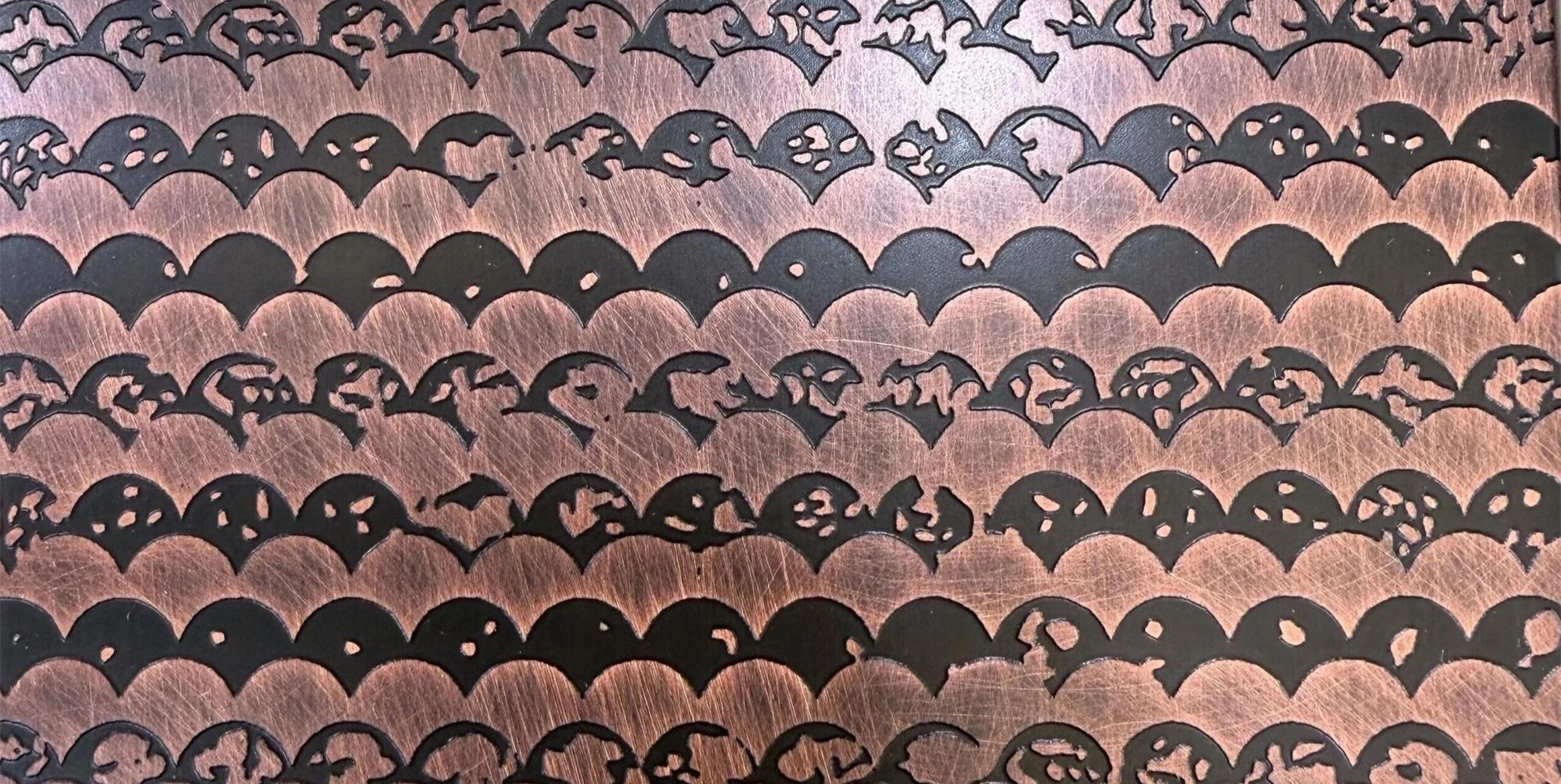 A finely etched stainless steel surface in a warm tone, the pattern continuing across the panel