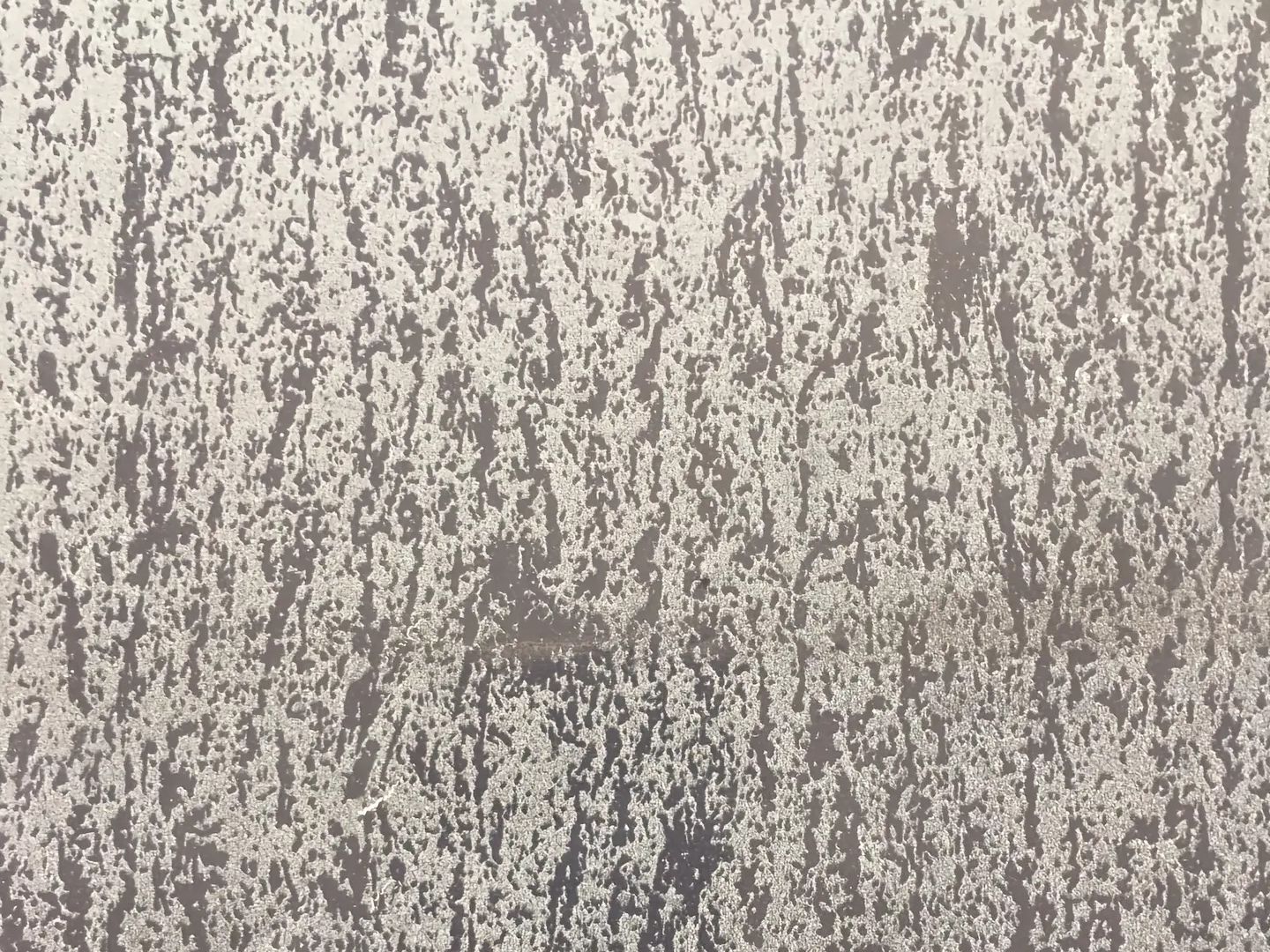An abstract printed stainless steel surface with a fine non-figurative stone texture