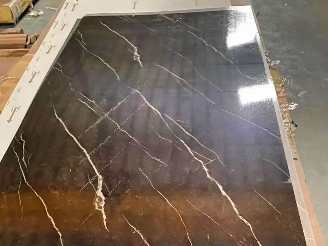 A printed stainless steel surface with strong light and dark contrast between the graphic and the metal ground