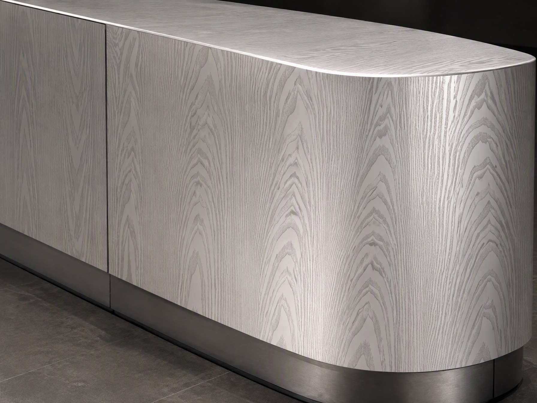A curved bespoke counter in wood-effect printed stainless steel, the pattern carried around the radius and edge