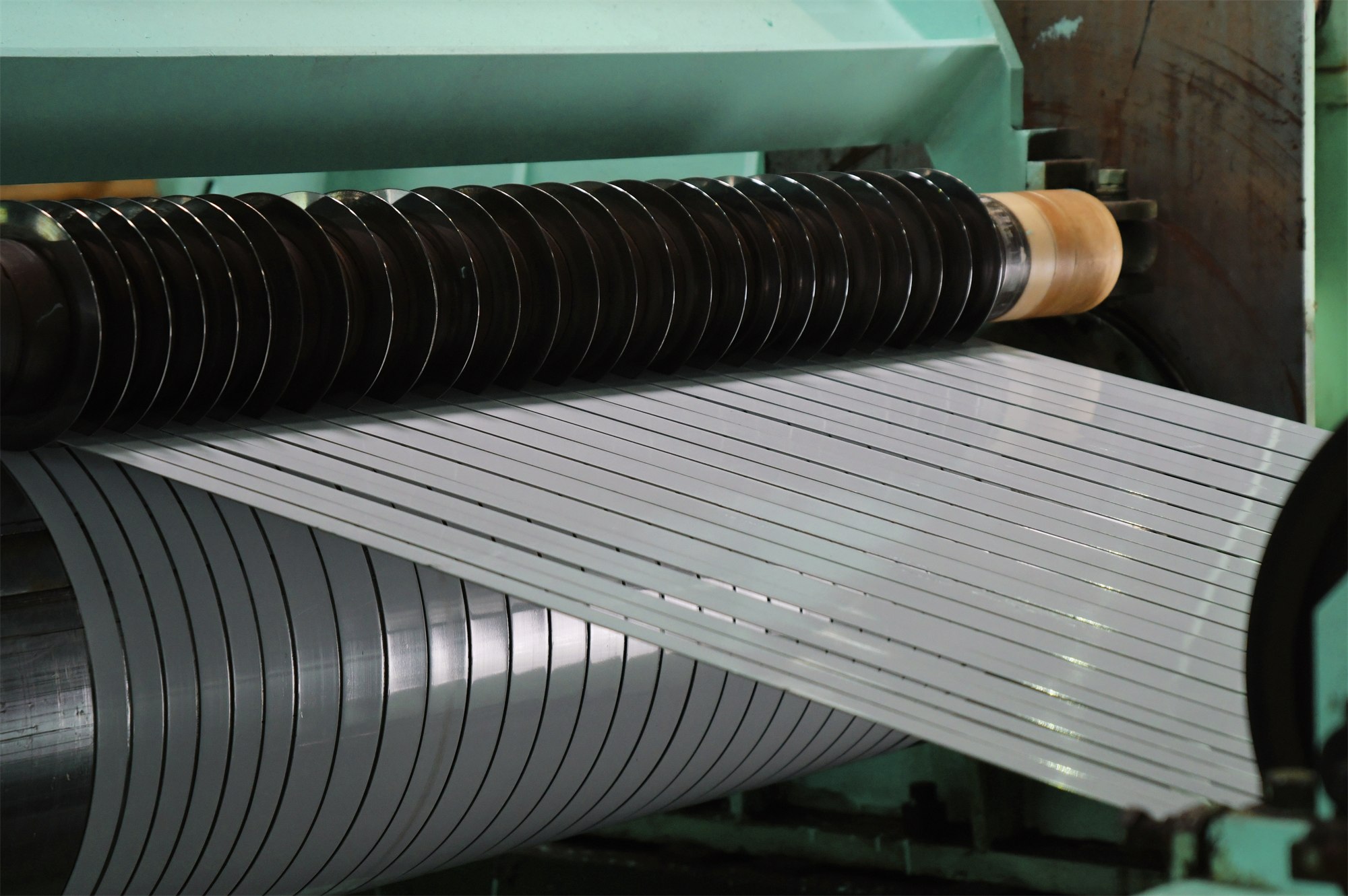 A stainless steel slitting line where printed sheet is cut into component widths with the graphic aligned to the cut