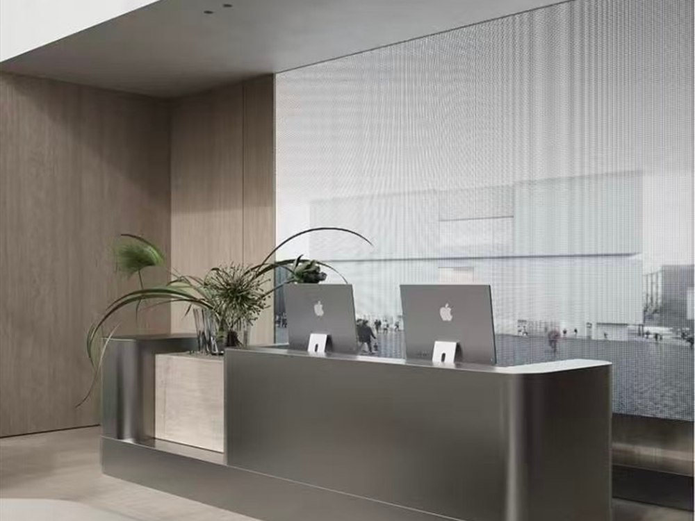 A brushed stainless steel reception counter in a bright lobby