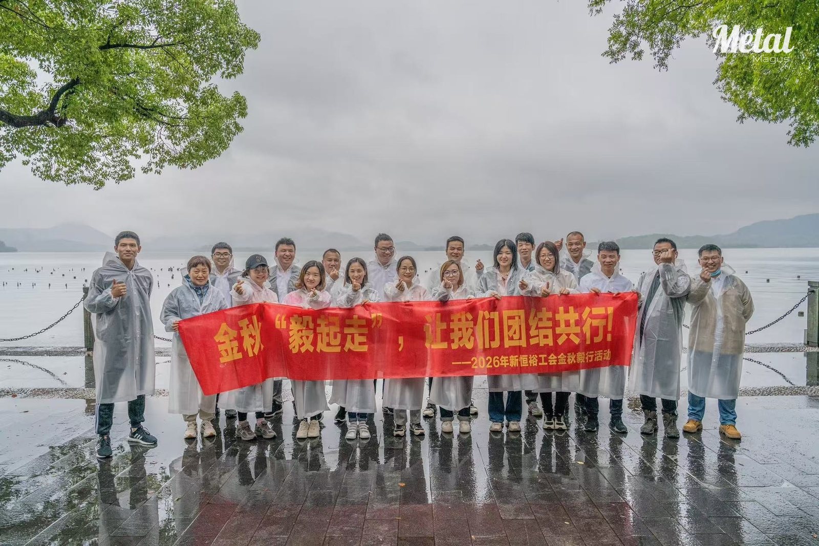 MetalMagus employees standing together at the edge of West Lake on a rainy afternoon