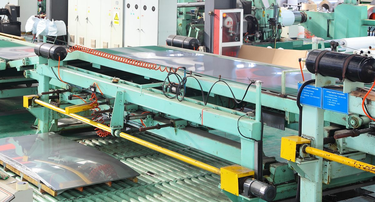 Cut-to-length and levelling line processing stainless steel sheet across a roller bed