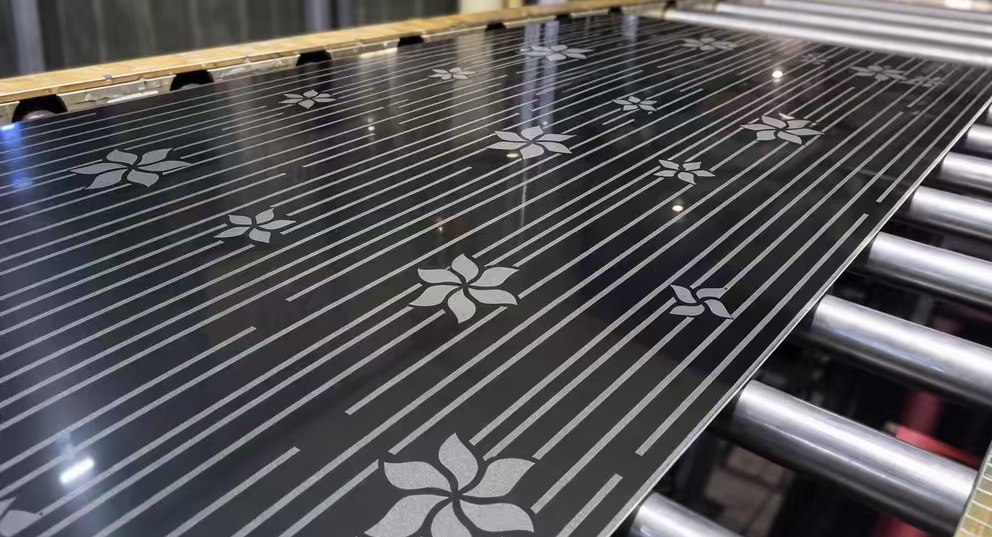 Floral and linear etched pattern on black stainless steel sheet leaving the etching line
