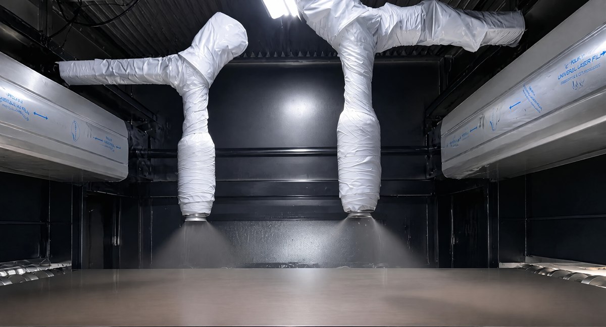 Two spray nozzles applying nano anti-fingerprint coating to a stainless steel sheet inside the coating booth
