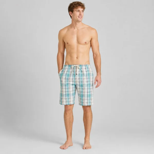 Model wearing aqua plaid men's cotton pajama shorts with a drawstring waist