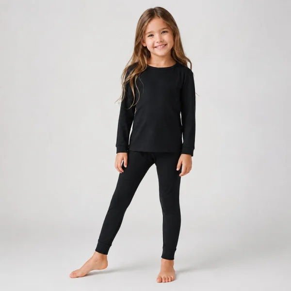 Girl wearing a solid black kids loungewear set with a long sleeve top and matching leggings