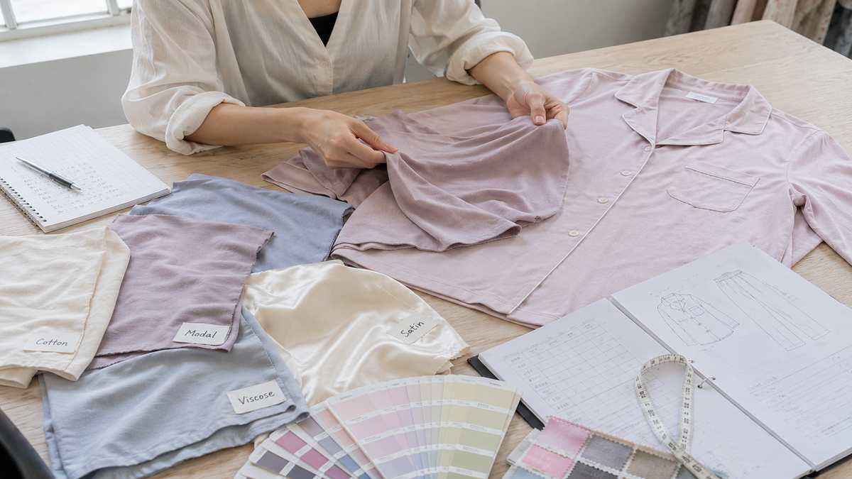 Sleepwear developer comparing pajama fabrics before creating a custom garment sample