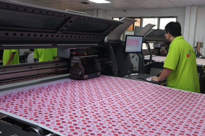 Operator running a digital textile printer with a custom print for a sleepwear order