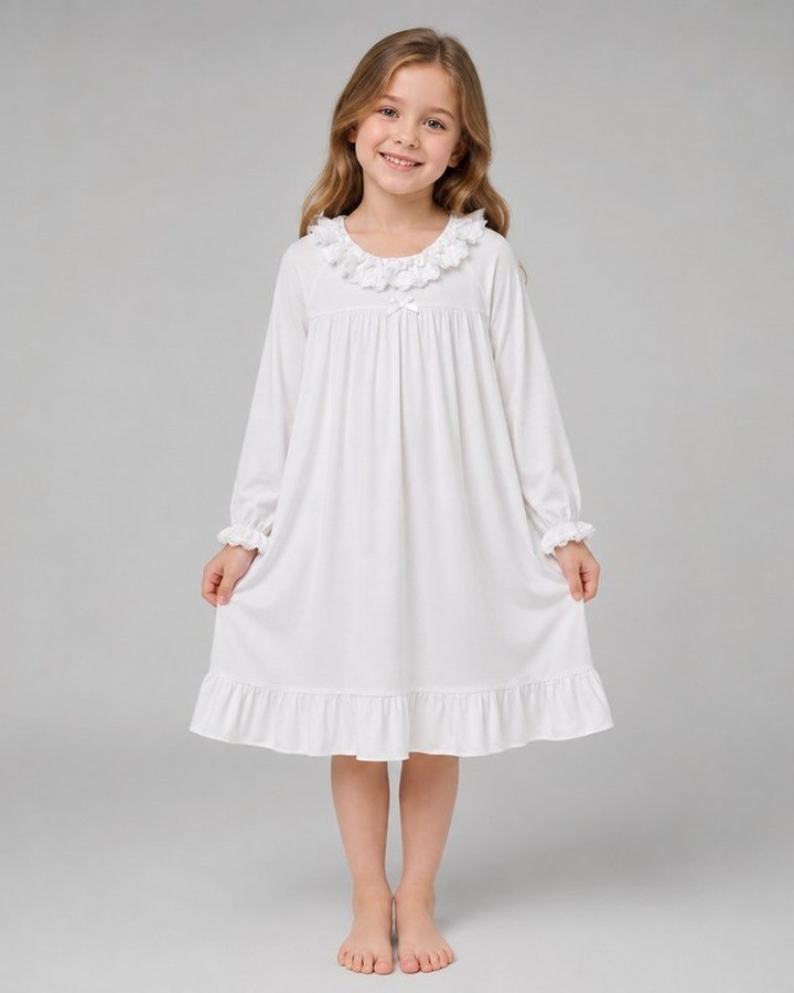 Girl wearing a white ruffle collar cotton nightgown with ruffled cuffs and hem from the kids sleepwear range