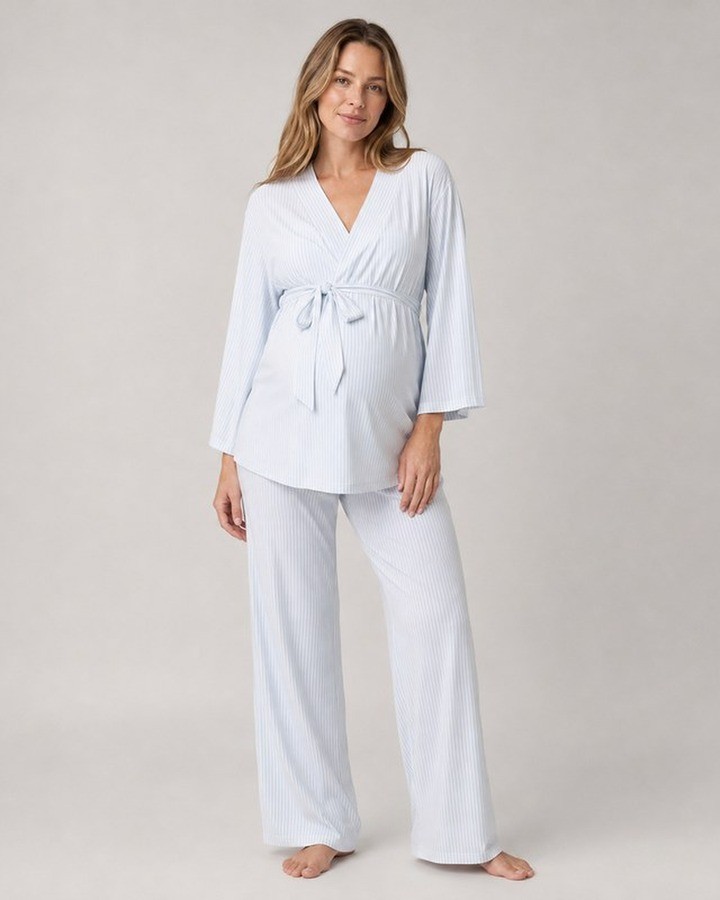 Pregnant model wearing a light blue and white striped maternity pajama set with a wrap front and tie waist