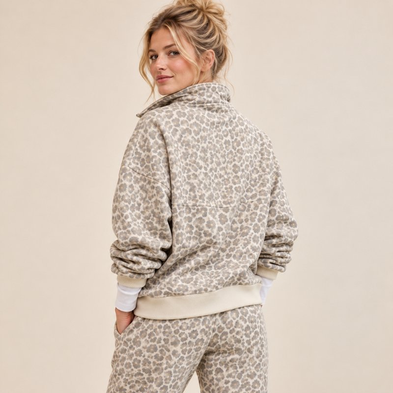 Close view of the contrast cream rib cuff and hood on a leopard print half-zip hoodie set