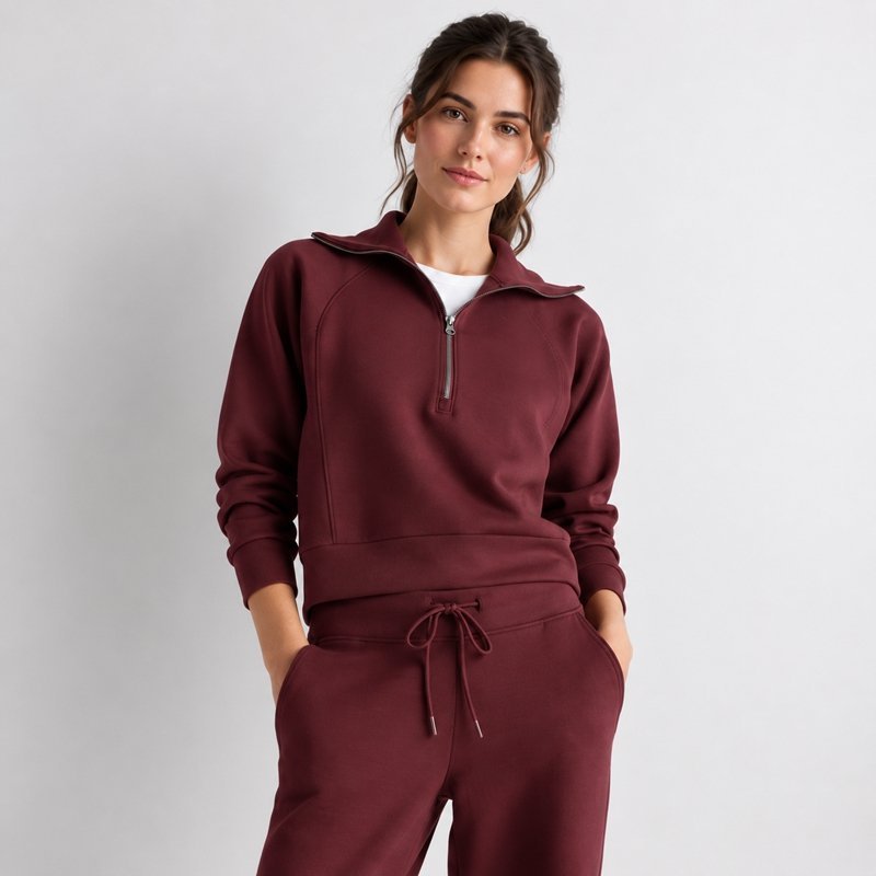 Close view of the half-zip stand collar and wide-leg pants on a burgundy knit lounge set