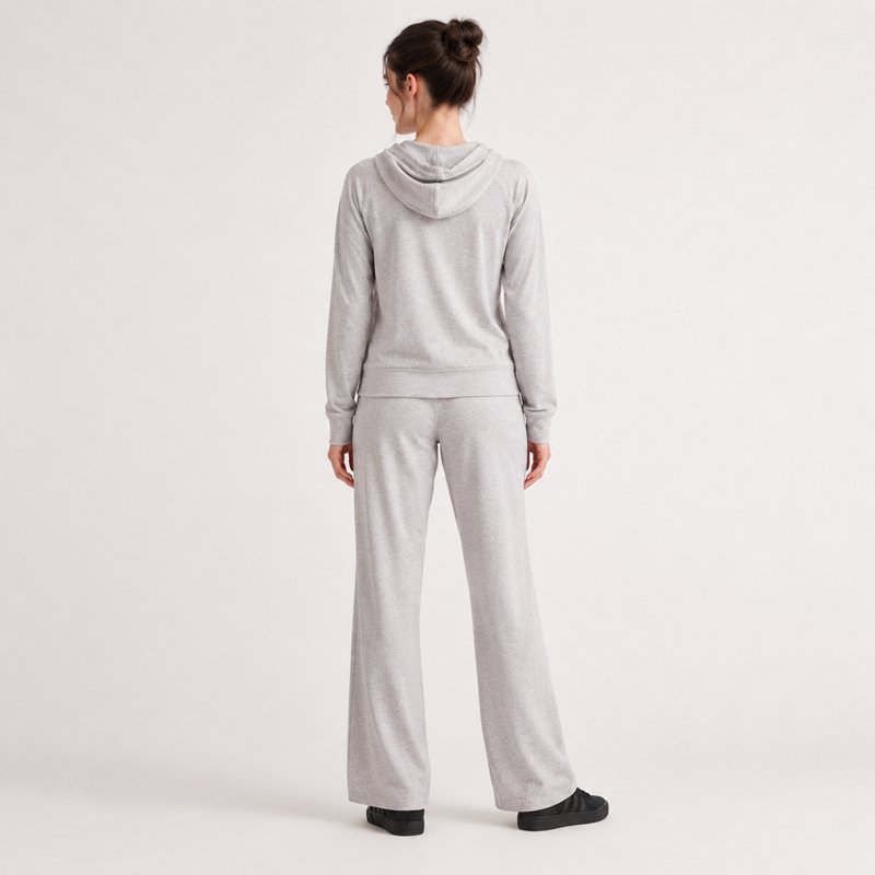 Close view of the lined hood and kangaroo pocket on a light grey hoodie and wide-leg pants set