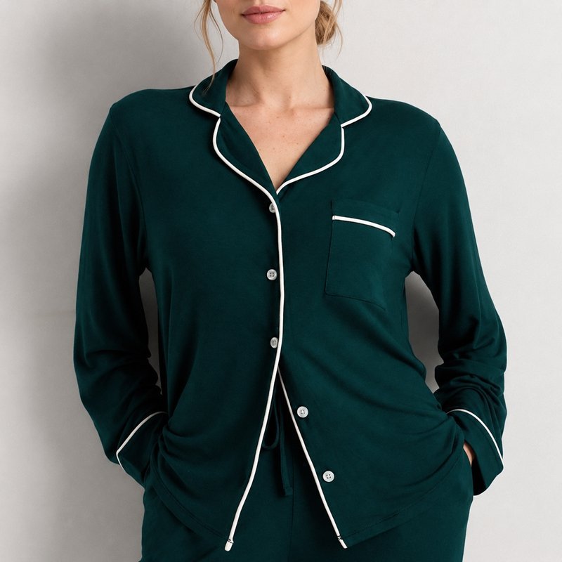 Close view of the white contrast piping and notch collar on a deep green bamboo jersey pajama set