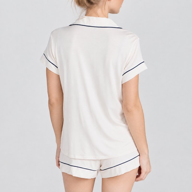 Close view of the contrast piping along the notch collar and sleeve cuff on a white jersey pajama set