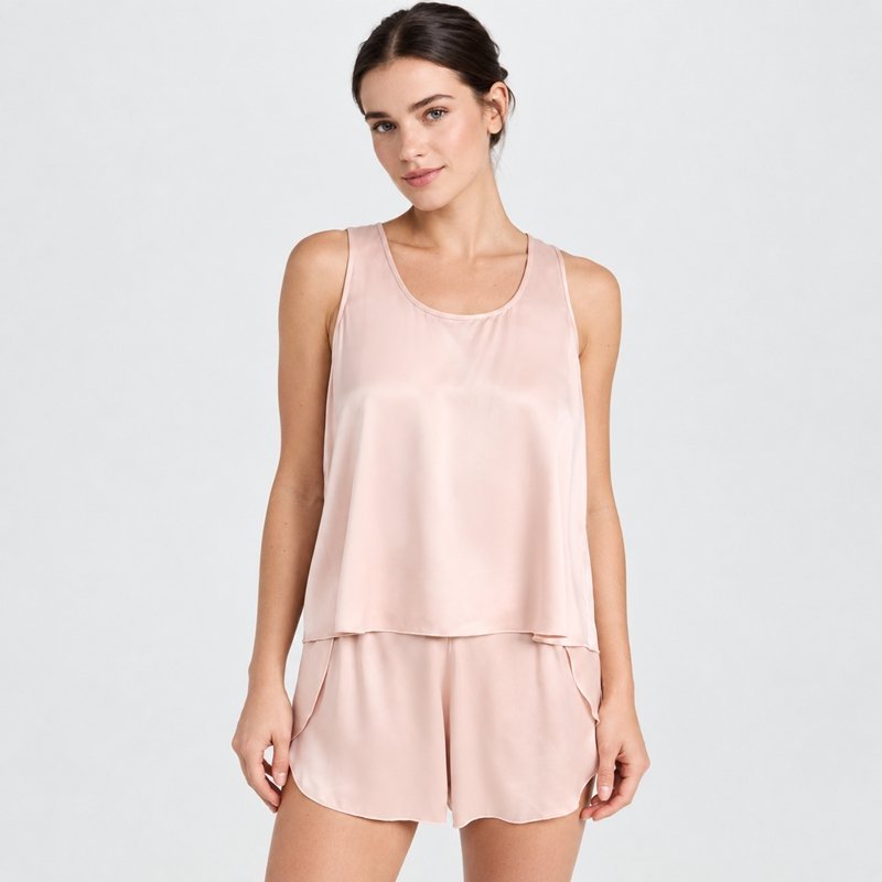 Close view of the tiered layered hem on a pink satin cami and shorts set