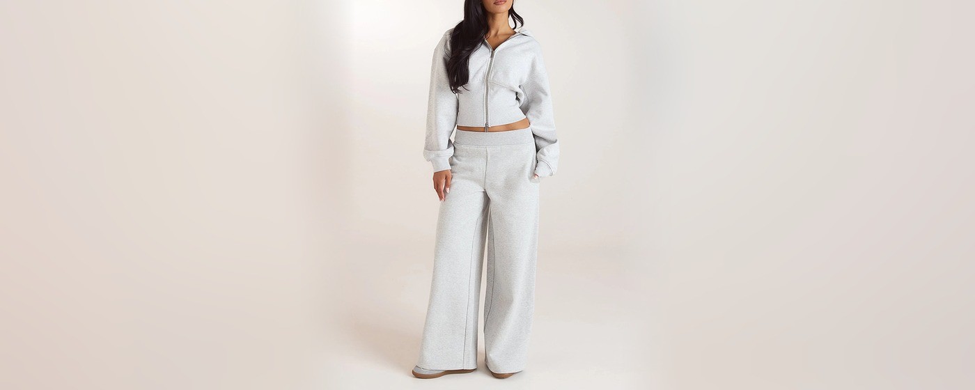 Pearl grey cropped zip-up hoodie with a fitted ribbed waist worn with matching wide leg sweatpants
