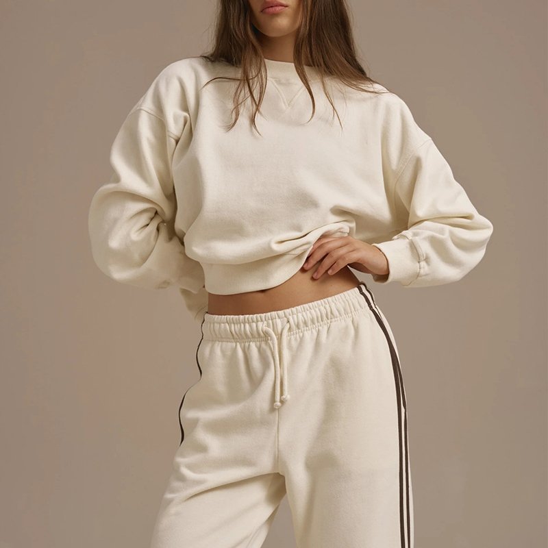 V stitch neckline and drop shoulder seam detail on a cream oversized crewneck sweatshirt