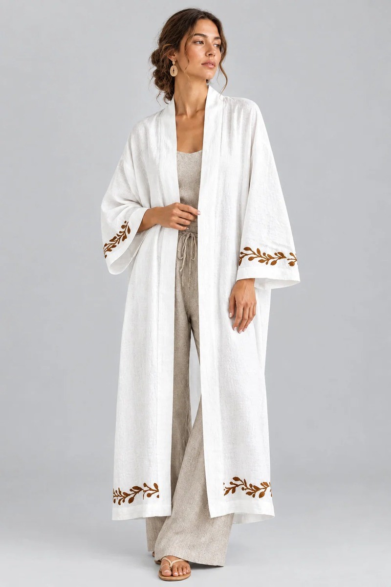 Long white kimono-style robe with wide sleeves and brown leaf embroidery, worn over a linen outfit