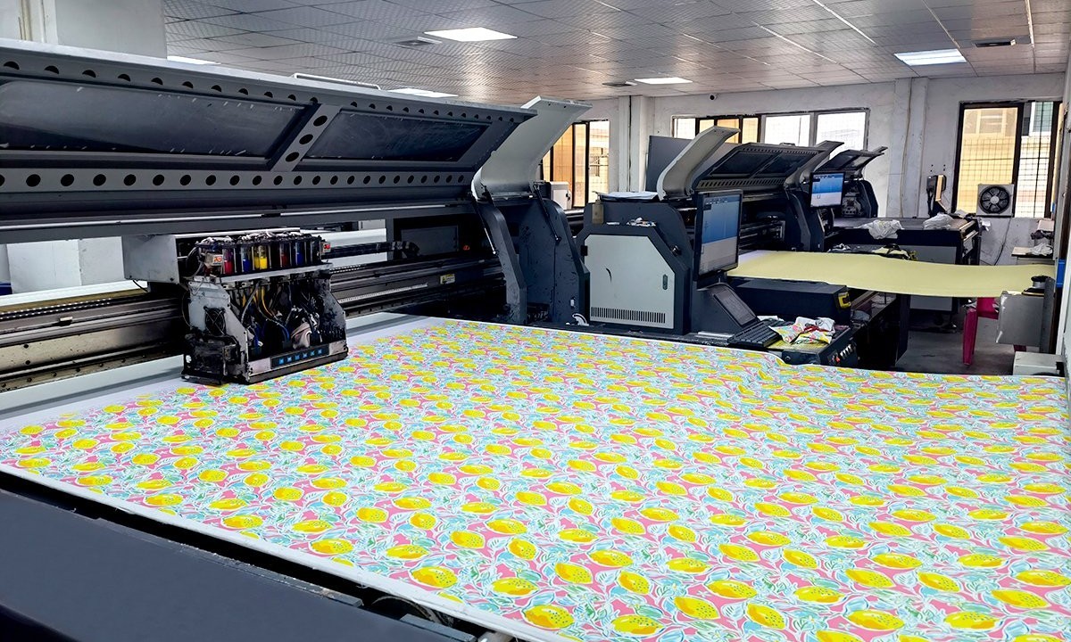 Large-format dye-sublimation printer printing a yellow and pink floral pattern onto fabric