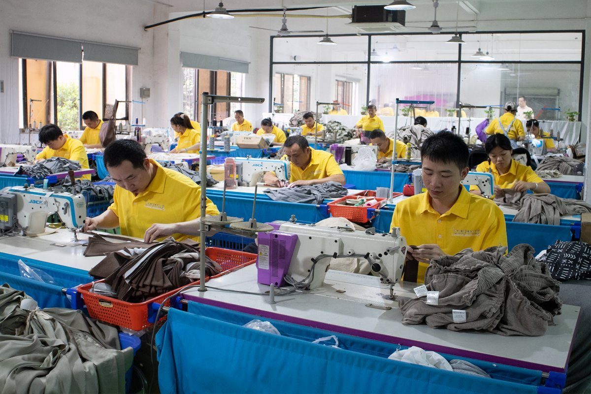 Rows of sewing operators at industrial machines assembling garments in a sleepwear factory