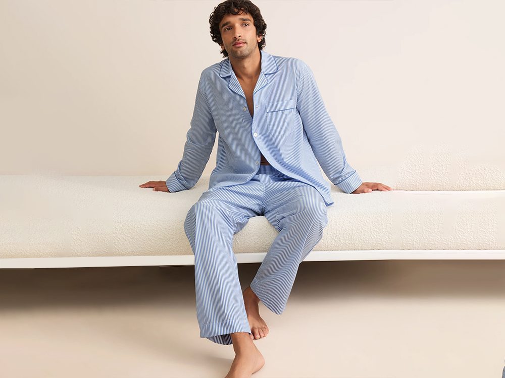 Man wearing a blue and white striped woven cotton men's pajama set, produced for private label sleepwear brands