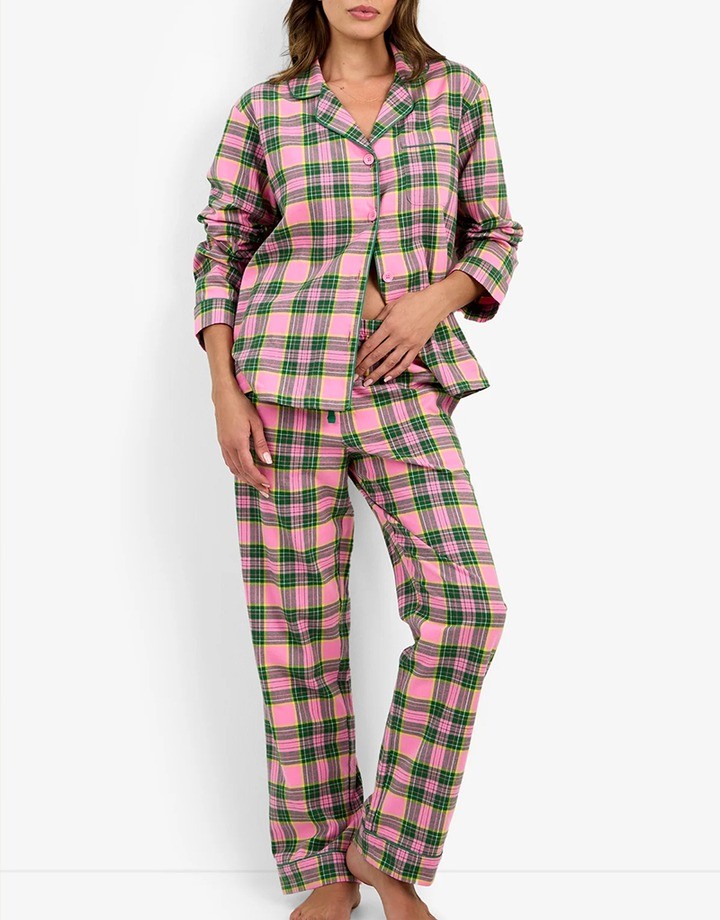 Woman wearing a pink, green and grey plaid pajama set with a notched collar and button front