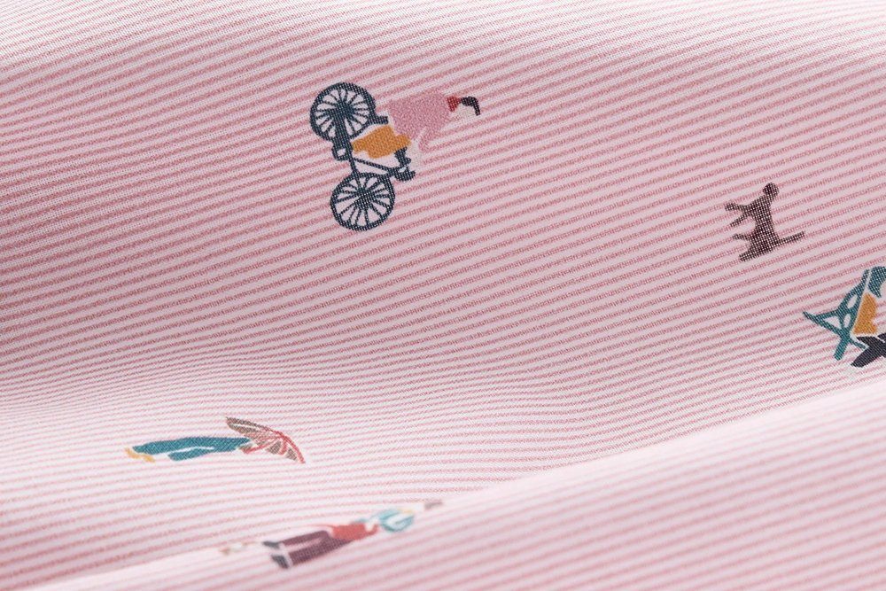 Close-up of a fine pink and white striped fabric printed with small bicycle and bird motifs