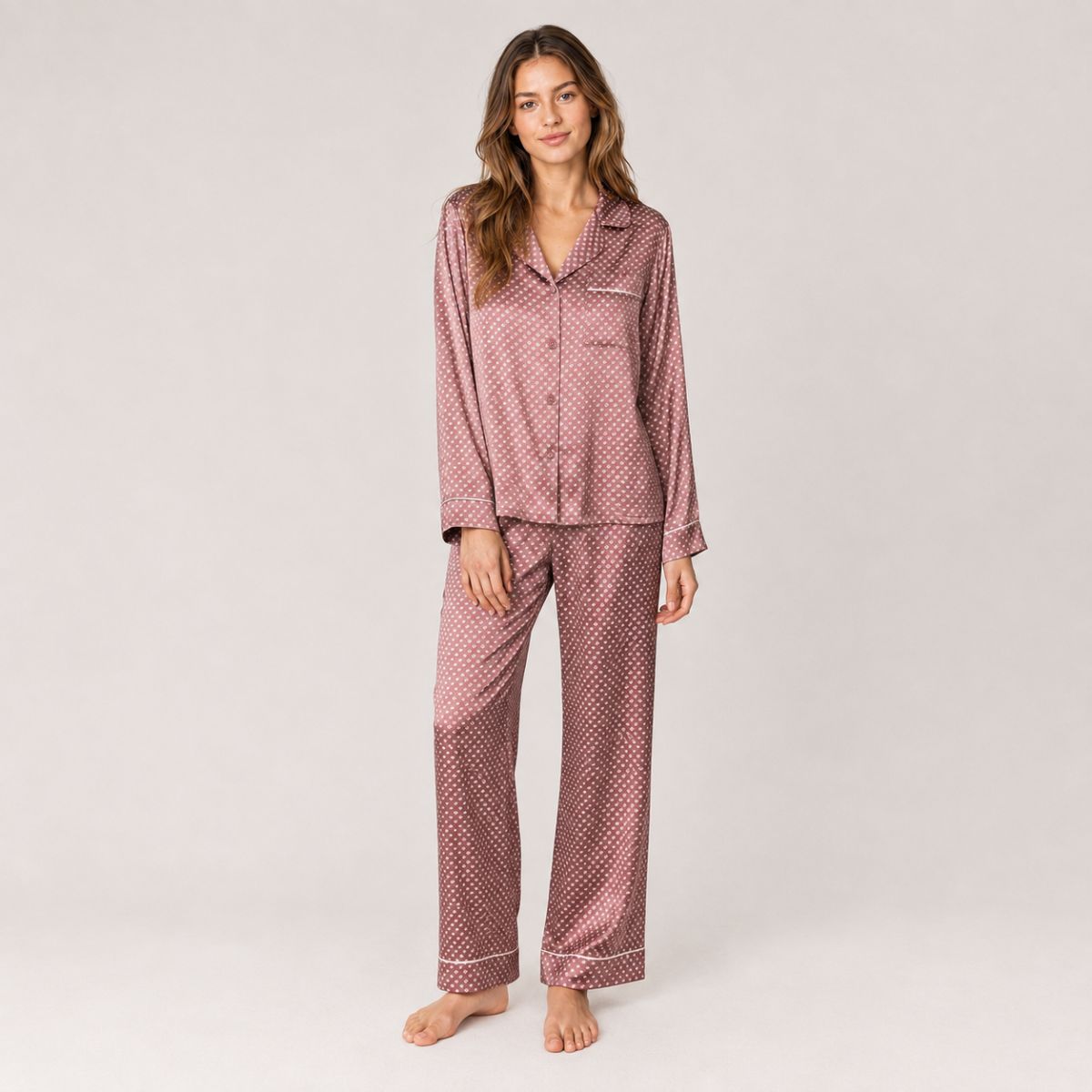 Model wearing a rose geometric-print satin pajama set with contrast piping