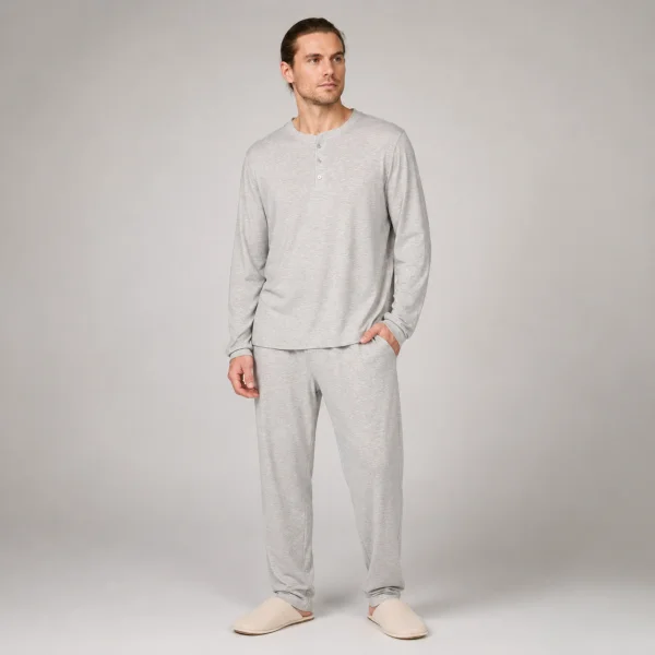 Model wearing a light grey men's cotton knit lounge set with a henley neck top and matching pants