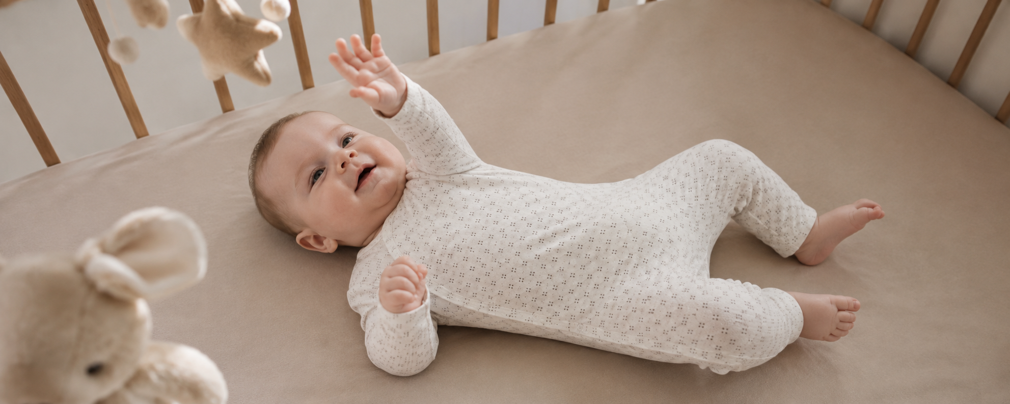 Organic cotton baby romper with wrap-front snap closure, long sleeves and footless design for private label infant sleepwear