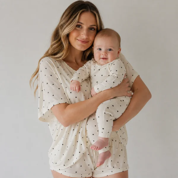 Mother holding a baby in matching ivory and black modal pajamas