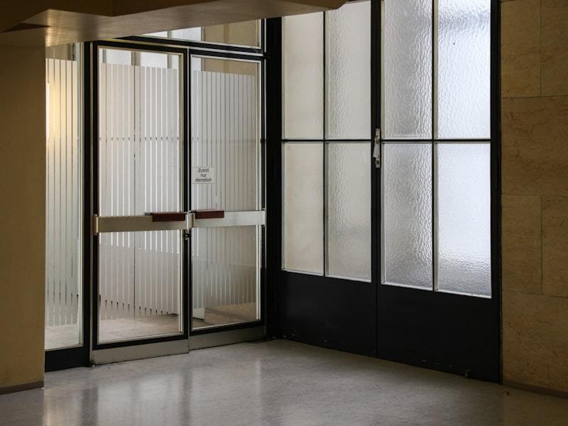 Aluminum entry door frame anchored and sealed at the threshold