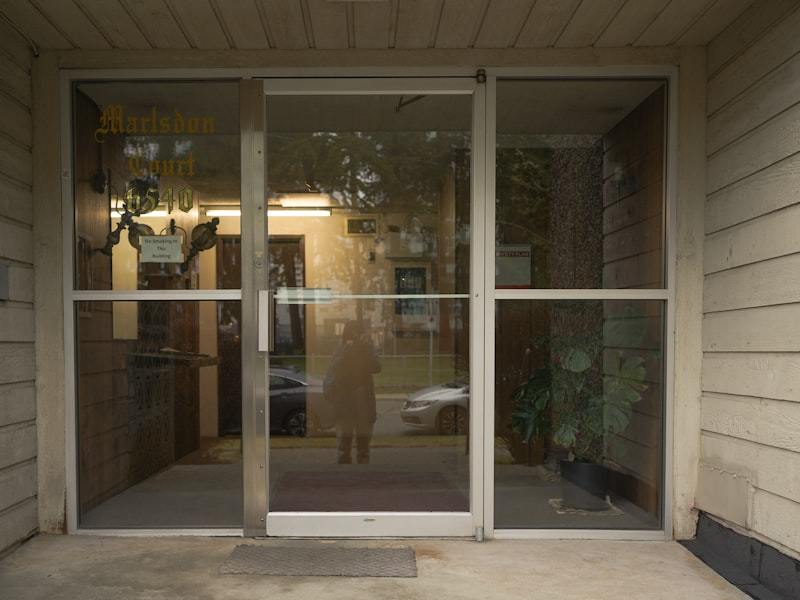 Contractor installing an aluminum entry door frame in a prepared rough opening
