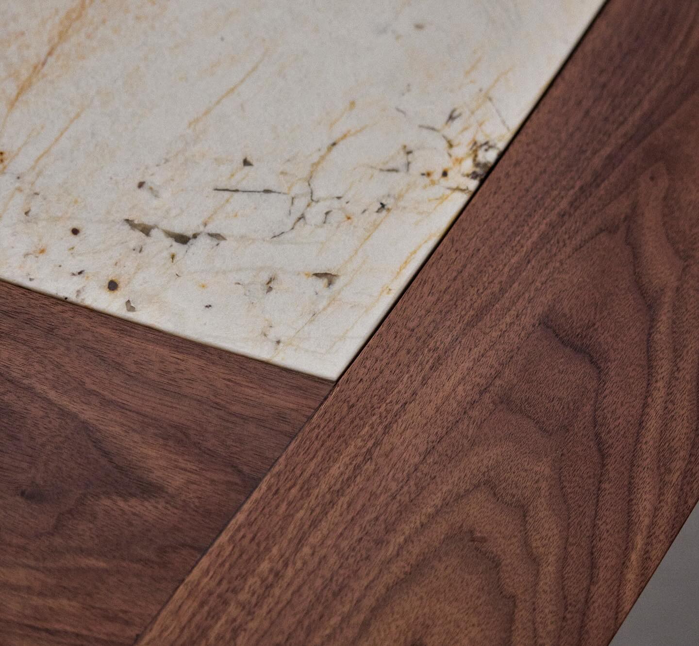 Close-up of the natural stone inlay set flush into the solid walnut frame of the octagonal tabletop