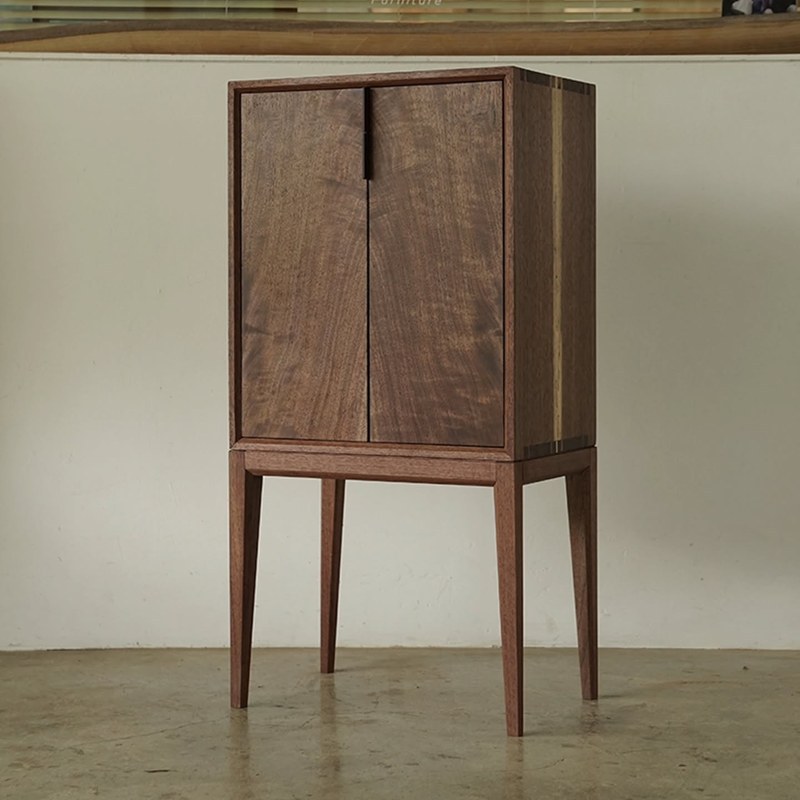 Walnut-tone tall storage cabinet with tapered legs for hotel guest rooms