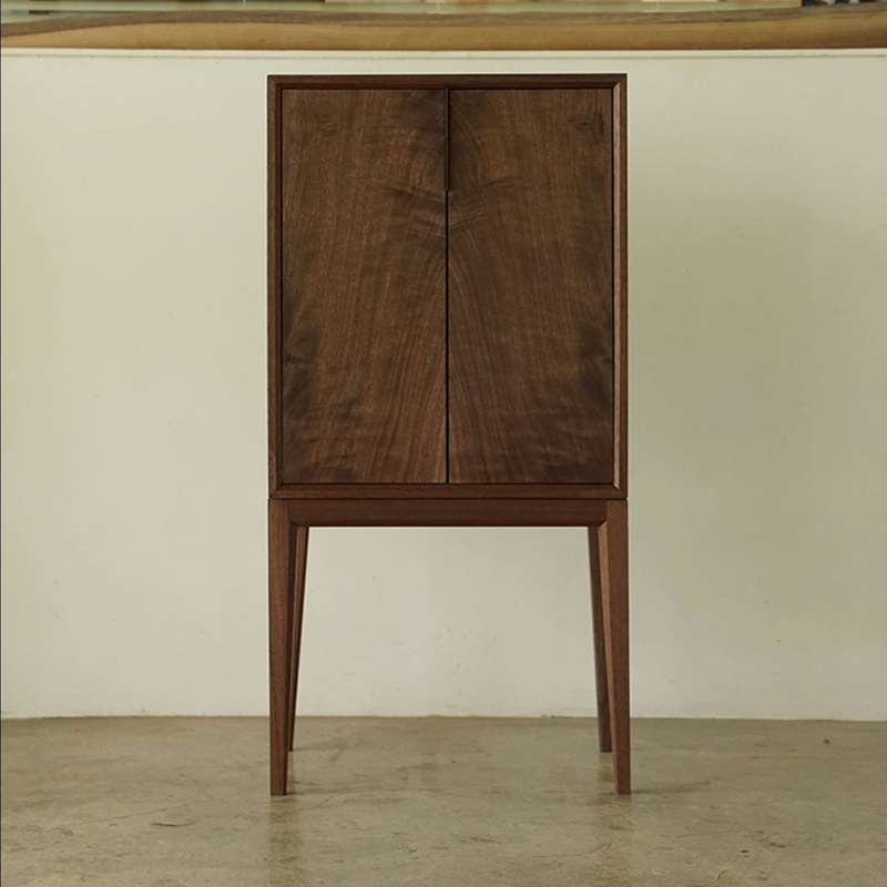 Front view of the tall storage cabinet with framed double doors and center pull