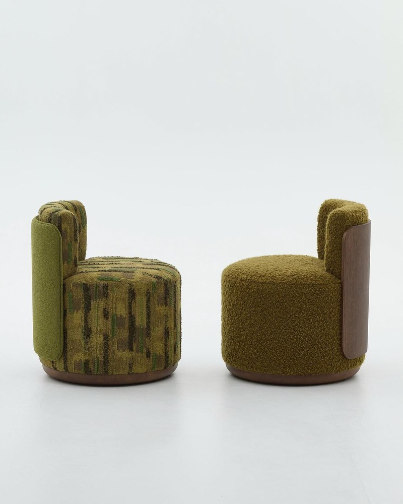 Two compact round hotel accent chairs in patterned olive fabric and textured moss green upholstery