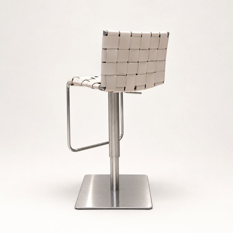 Rear three-quarter view of a beige woven bar stool with a brushed-metal pedestal