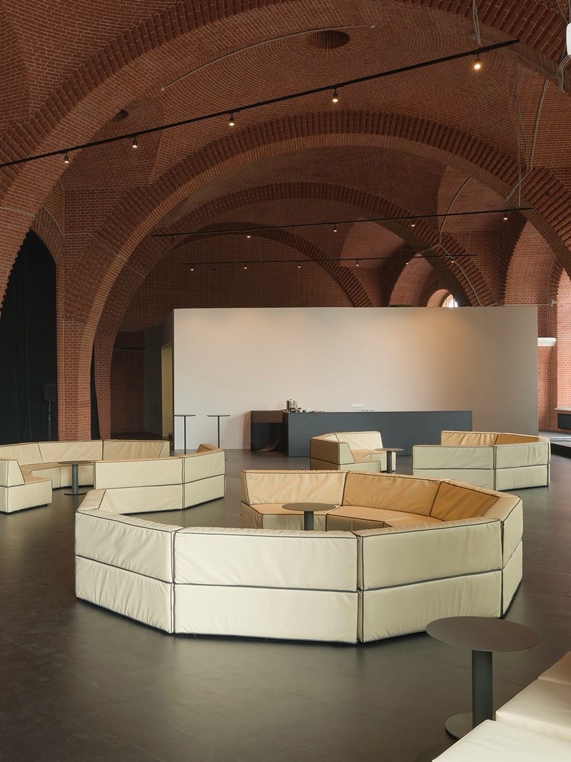 Low-back cream modular sofa forming a curved conversation area with dark contrast piping