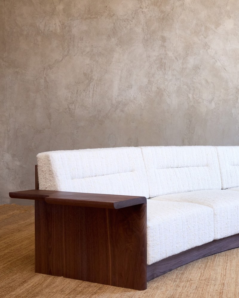 Side view of a curved hotel sofa wood arm showing the offset notch and vertical wood side panel