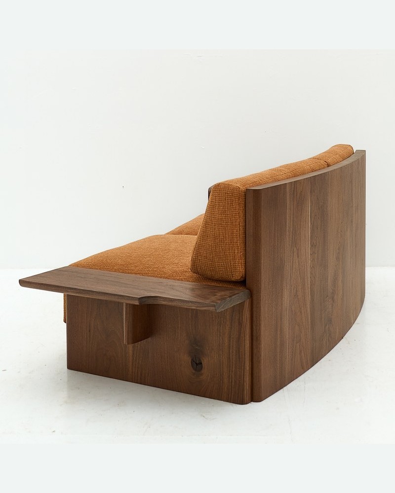 Side view of a luxury hotel suite sofa with a substantial curved wood back