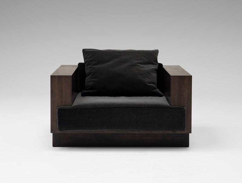 Front view of a custom brutalist walnut hotel lounge chair with broad squared arms and black velvet cushions