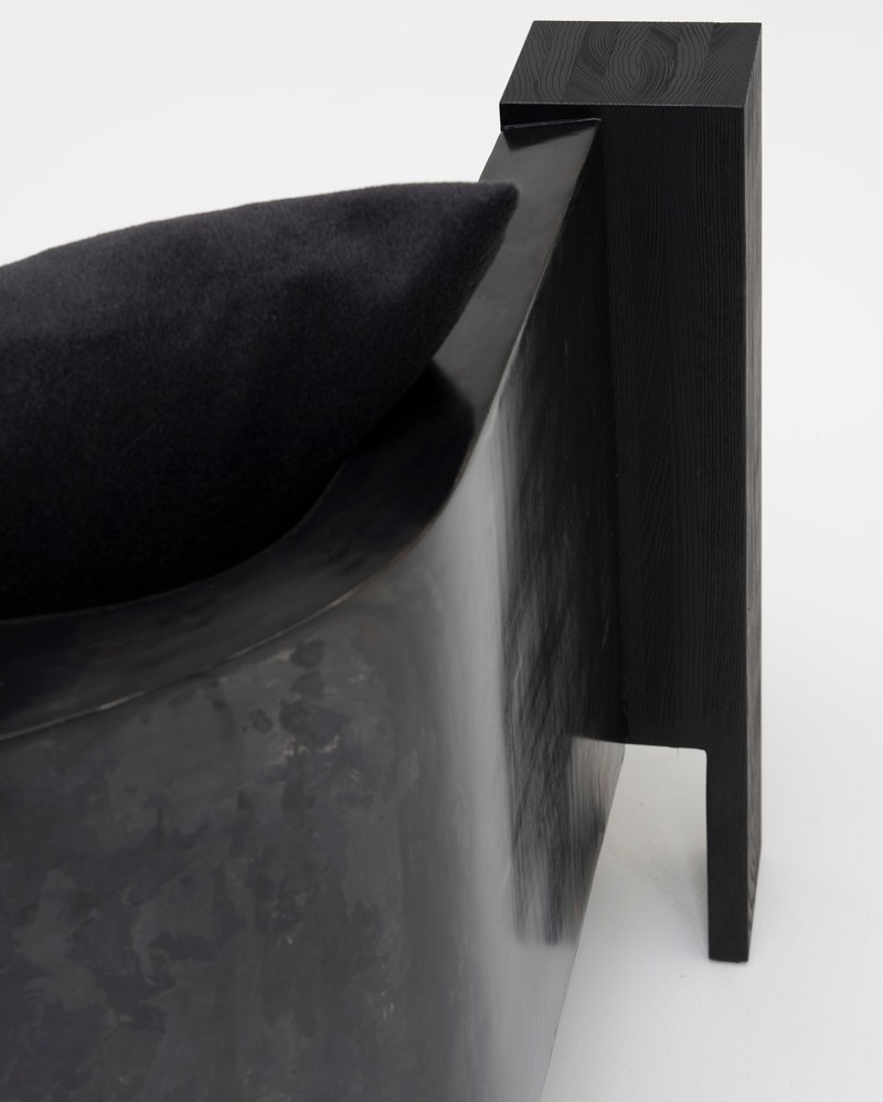 Close-up of black fabric sofa cushions, loose back pillows and the curved seating arrangement