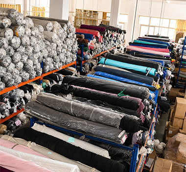 Fabric rolls organized in a garment manufacturing supply warehouse