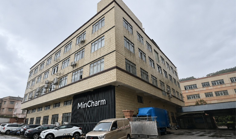 Exterior view of the MinCharm factory building with brand signage on the facade.