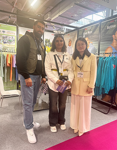 MinCharm team with trade show visitors at a UK apparel exhibition in 2024