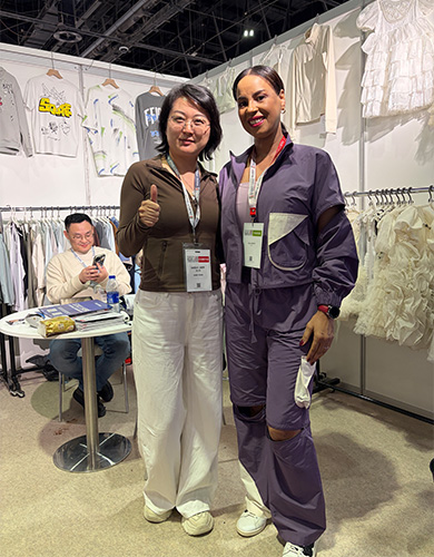 MinCharm representatives meeting a visitor at a Dubai apparel trade show in 2025